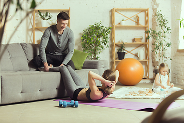 Image showing Young woman exercising fitness, aerobic, yoga at home, sporty lifestyle. Getting active during lockdown, quarantine. Home gym.