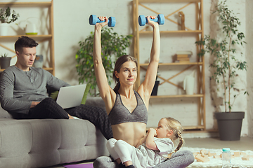 Image showing Young woman exercising fitness, aerobic, yoga at home, sporty lifestyle. Getting active during lockdown, quarantine. Home gym.