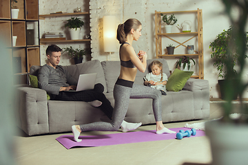 Image showing Young woman exercising fitness, aerobic, yoga at home, sporty lifestyle. Getting active during lockdown, quarantine. Home gym.