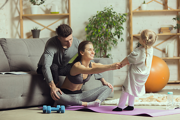 Image showing Young woman exercising fitness, aerobic, yoga at home, sporty lifestyle. Getting active during lockdown, quarantine. Home gym.