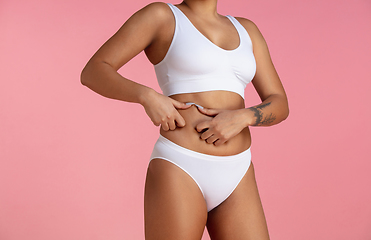 Image showing Beautiful body of young african-american woman isolated on pink studio background