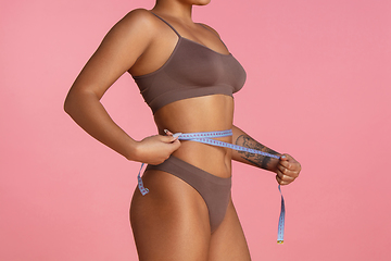 Image showing Beautiful body of young african-american woman isolated on pink studio background