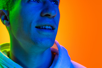 Image showing Caucasian beautiful man\'s portrait isolated on yellow studio background in multicolored neon light