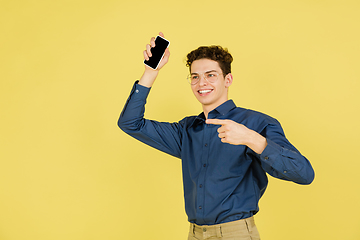 Image showing Caucasian man\'s portrait isolated on yellow studio background with copyspace