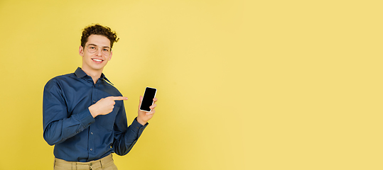 Image showing Caucasian man\'s portrait isolated on yellow studio background with copyspace