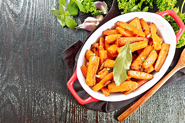 Image showing Carrots fried in pan on dark board top