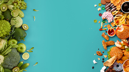 Image showing Fast and healthy food compared on turquoise background. Unhealthy set including burgers, sauces, french fries in comparison with vegetables, fruits, organic food