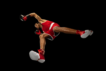 Image showing Young african-american boxer in action, motion isolated on black background, look from the bottom. Concept of sport, movement, energy and dynamic.