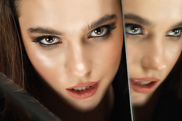 Image showing Portrait of female fashion model with reflections on mirrors around her face. Style and beauty concept. Close up.