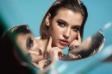 Image showing Portrait of female fashion model with reflections on mirrors around her face. Style and beauty concept. Close up.