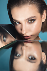 Image showing Portrait of female fashion model with reflections on mirrors around her face. Style and beauty concept. Close up.