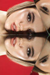 Image showing Portrait of female fashion model with reflections on mirrors around her face. Style and beauty concept. Close up.