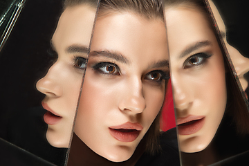 Image showing Portrait of female fashion model with reflections on mirrors around her face. Style and beauty concept. Close up.