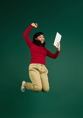 Image showing East asian woman\'s portrait isolated on green studio background with copyspace