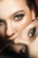 Image showing Portrait of female fashion model with reflections on mirrors around her face. Style and beauty concept. Close up.