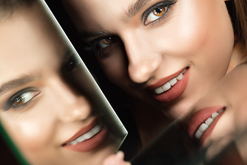 Image showing Portrait of female fashion model with reflections on mirrors around her face. Style and beauty concept. Close up.