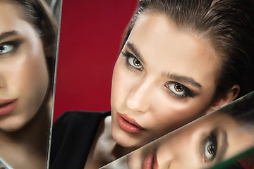 Image showing Portrait of female fashion model with reflections on mirrors around her face. Style and beauty concept. Close up.