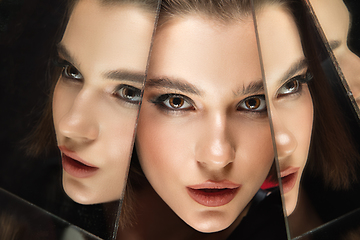 Image showing Portrait of female fashion model with reflections on mirrors around her face. Style and beauty concept. Close up.