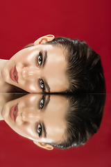 Image showing Portrait of female fashion model with reflections on mirrors around her face. Style and beauty concept. Close up.