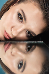 Image showing Portrait of female fashion model with reflections on mirrors around her face. Style and beauty concept. Close up.