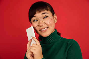 Image showing East asian woman\'s portrait isolated on red studio background with copyspace