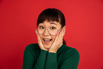 Image showing East asian woman\'s portrait isolated on red studio background with copyspace