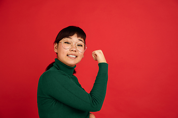 Image showing East asian woman\'s portrait isolated on red studio background with copyspace