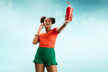 Image showing Portrait of female fashion model on blue sky background. Style and beauty concept, bright appearance