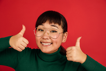 Image showing East asian woman\'s portrait isolated on red studio background with copyspace