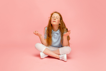 Image showing Happy redhair girl isolated on pink studio background. Looks happy, cheerful, sincere. Copyspace. Childhood, education, emotions concept