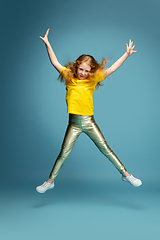 Image showing Happy redhair girl isolated on blue studio background. Looks happy, cheerful, sincere. Copyspace. Childhood, education, emotions concept