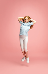 Image showing Happy redhair girl isolated on pink studio background. Looks happy, cheerful, sincere. Copyspace. Childhood, education, emotions concept