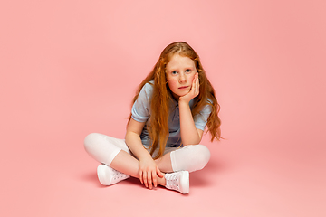 Image showing Happy redhair girl isolated on pink studio background. Looks happy, cheerful, sincere. Copyspace. Childhood, education, emotions concept