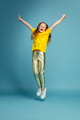 Image showing Happy redhair girl isolated on blue studio background. Looks happy, cheerful, sincere. Copyspace. Childhood, education, emotions concept