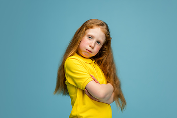 Image showing Happy redhair girl isolated on blue studio background. Looks happy, cheerful, sincere. Copyspace. Childhood, education, emotions concept