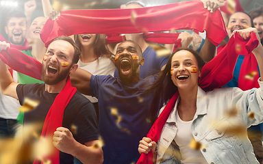 Image showing Spainian football, soccer fans cheering their team with a red scarfs at stadium. Excited fans cheering a goal, supporting favourite players