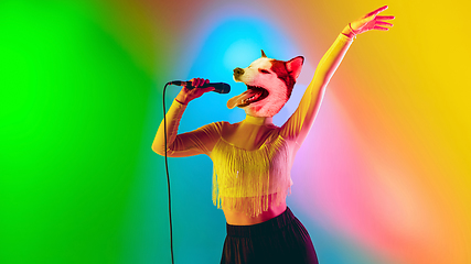 Image showing Talented dog, professional musician performing on multicoloted background in neon light. Concept of music, hobby, festival, contemporary art collage. Modern design.