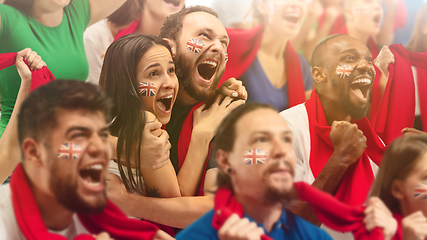 Image showing Britainian football, soccer fans cheering their team with a red scarfs at stadium. Excited fans cheering a goal, supporting favourite players