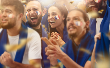 Image showing Francian football, soccer fans cheering their team with a blue scarfs at stadium. Excited fans cheering a goal, supporting favourite players