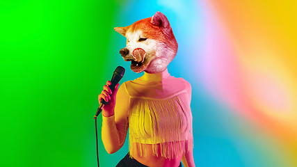 Image showing Talented dog, professional musician performing on multicoloted background in neon light. Concept of music, hobby, festival, contemporary art collage. Modern design.