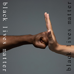 Image showing African and caucasian hands gesturing on gray studio background, tolerance and equality concept