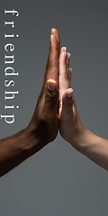 Image showing African and caucasian hands gesturing on gray studio background, tolerance and equality concept