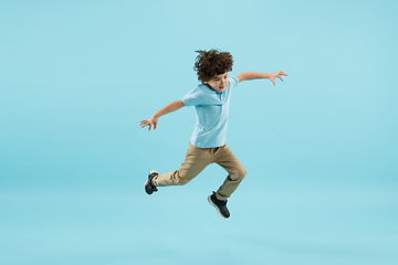 Image showing Childhood and dream about big and famous future. Pretty little boy isolated on blue background