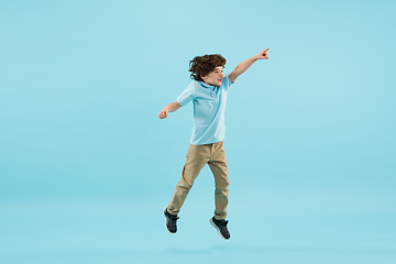 Image showing Childhood and dream about big and famous future. Pretty little boy isolated on blue background