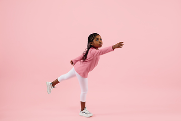 Image showing Childhood and dream about big and famous future. Pretty little girl isolated on coral pink background