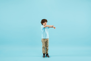 Image showing Childhood and dream about big and famous future. Pretty little boy isolated on blue background