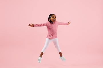 Image showing Childhood and dream about big and famous future. Pretty little girl isolated on coral pink background