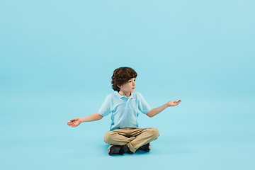 Image showing Childhood and dream about big and famous future. Pretty little boy isolated on blue background