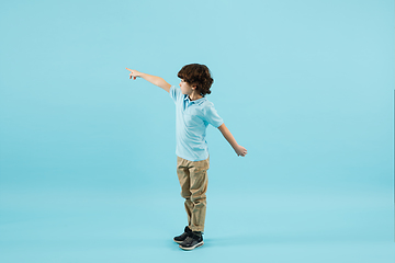 Image showing Childhood and dream about big and famous future. Pretty little boy isolated on blue background