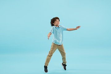 Image showing Childhood and dream about big and famous future. Pretty little boy isolated on blue background